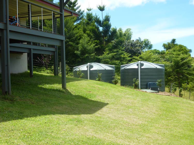 green water tanks at back of home
